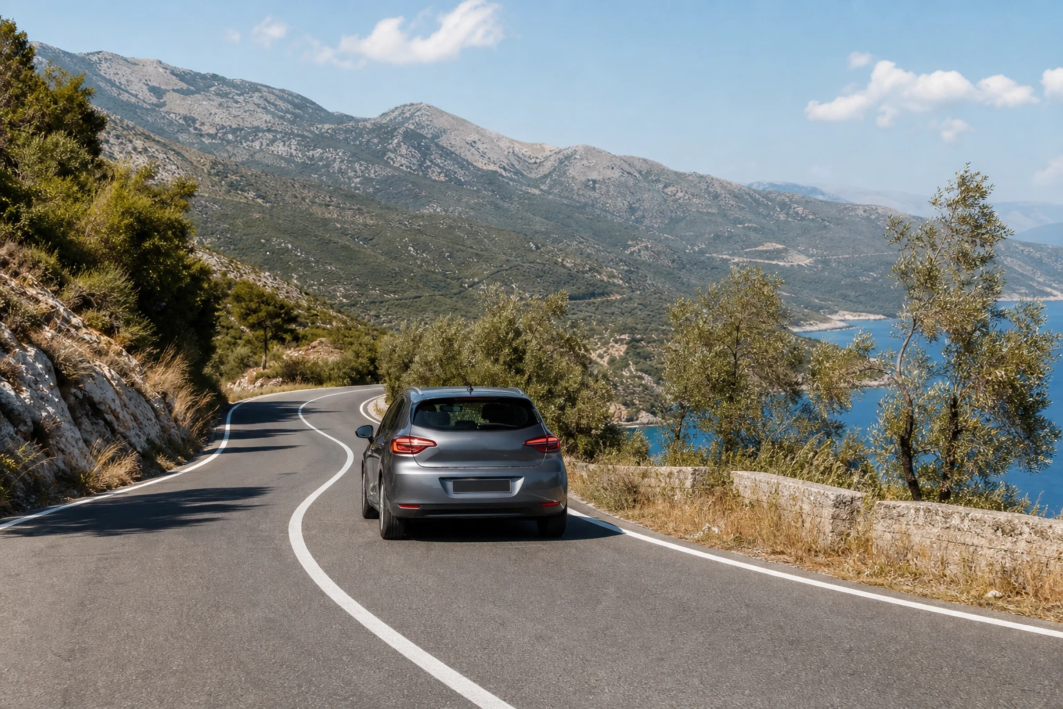 Rental car on a coastal mountain road in Albania