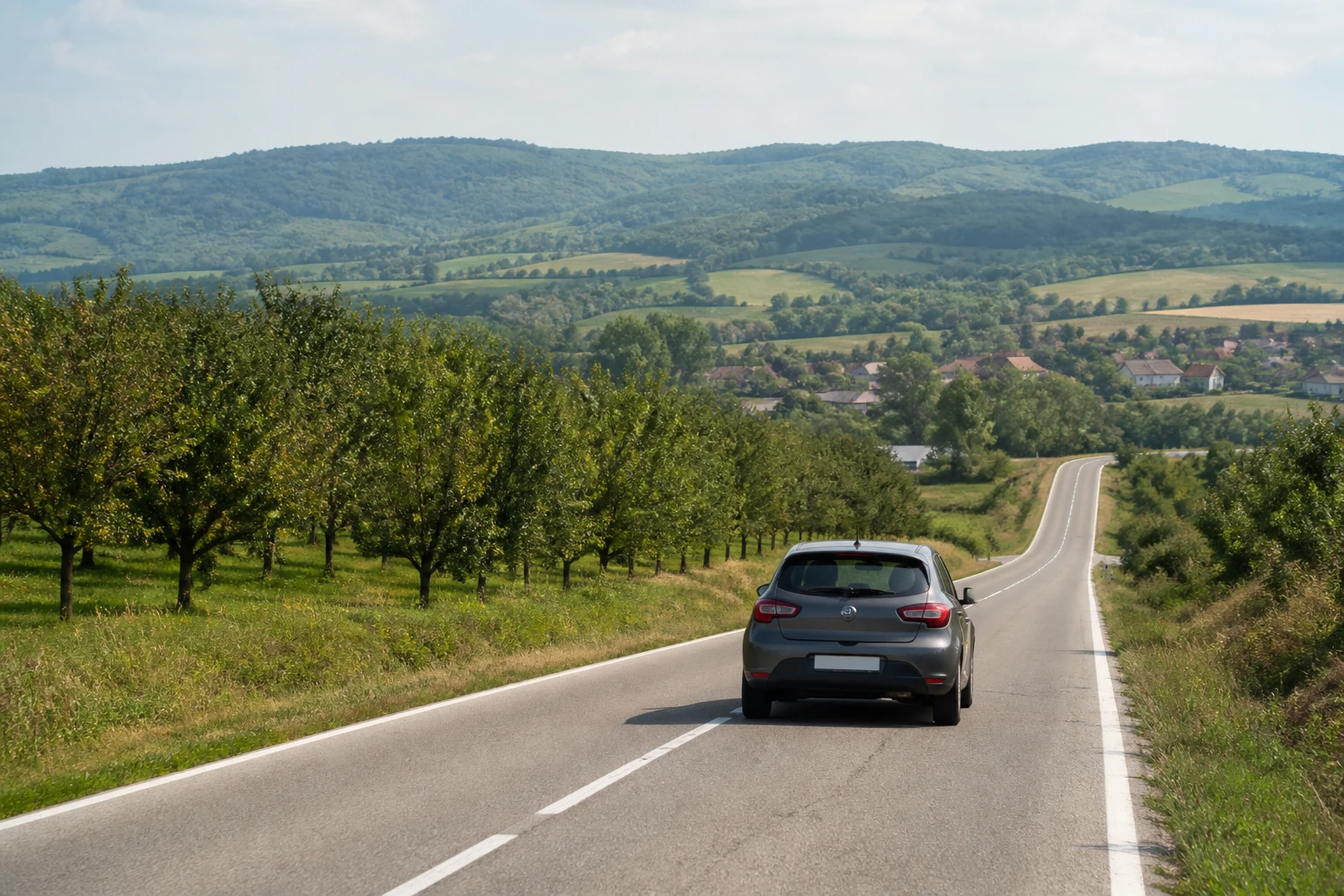 Rental car on a country road through rolling Serbian countryside