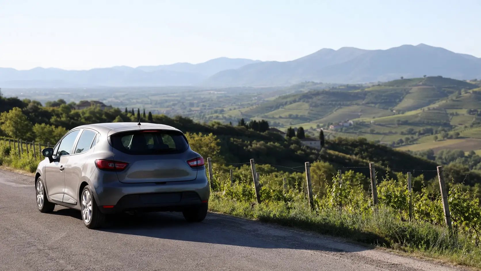 Rental car on a Lombardy road near Brescia with hills beyond