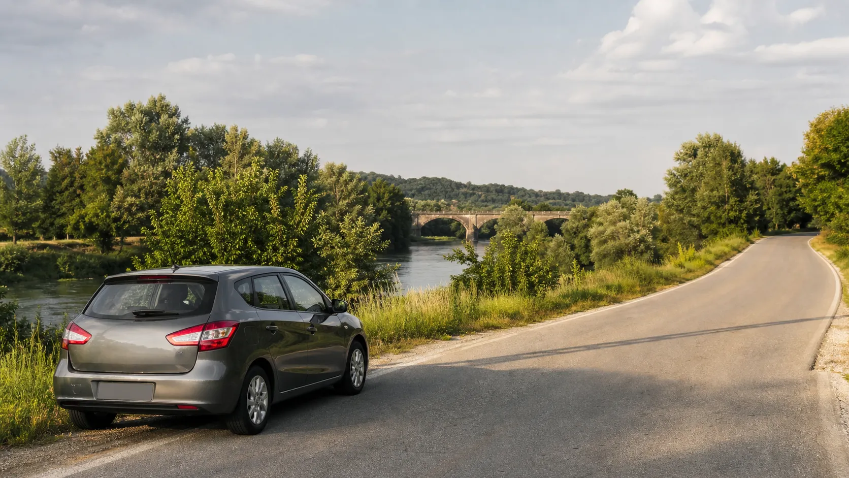 Rental car beside a river road and stone bridge near Karlovac in central Croatia