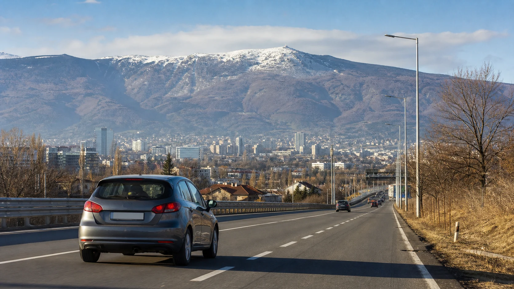 Rental car leaving Sofia on a road with Vitosha mountain and the city behind