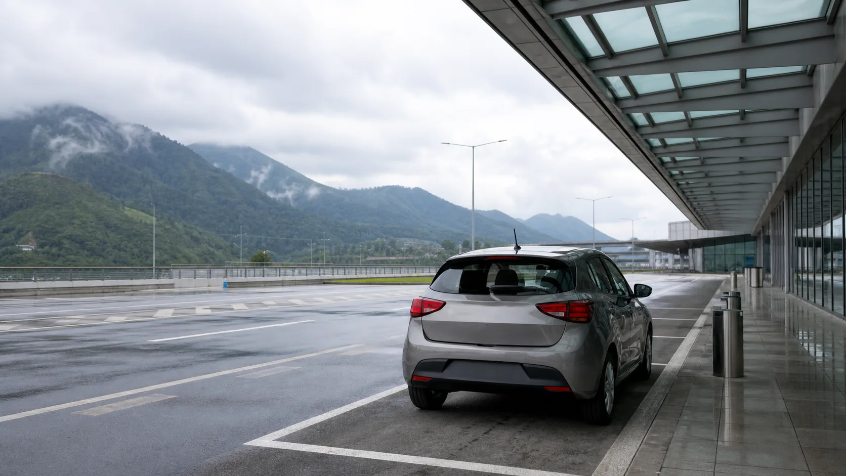 Illustrative rental car at a generic airport pickup bay beside misty green hills
