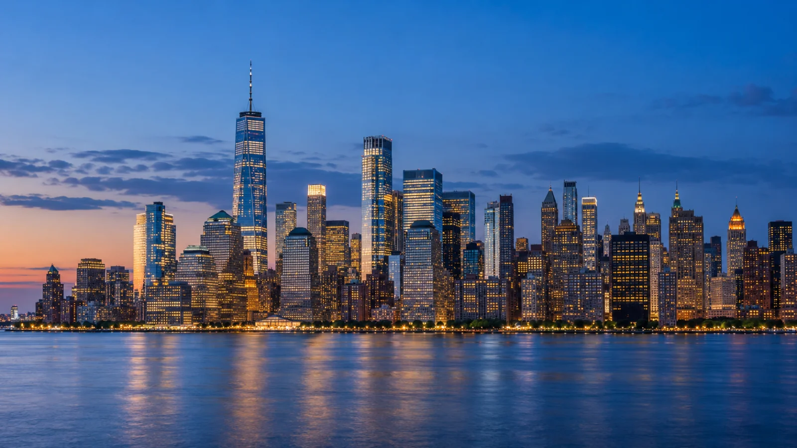 Illuminated downtown skyline reflected in a river at dusk