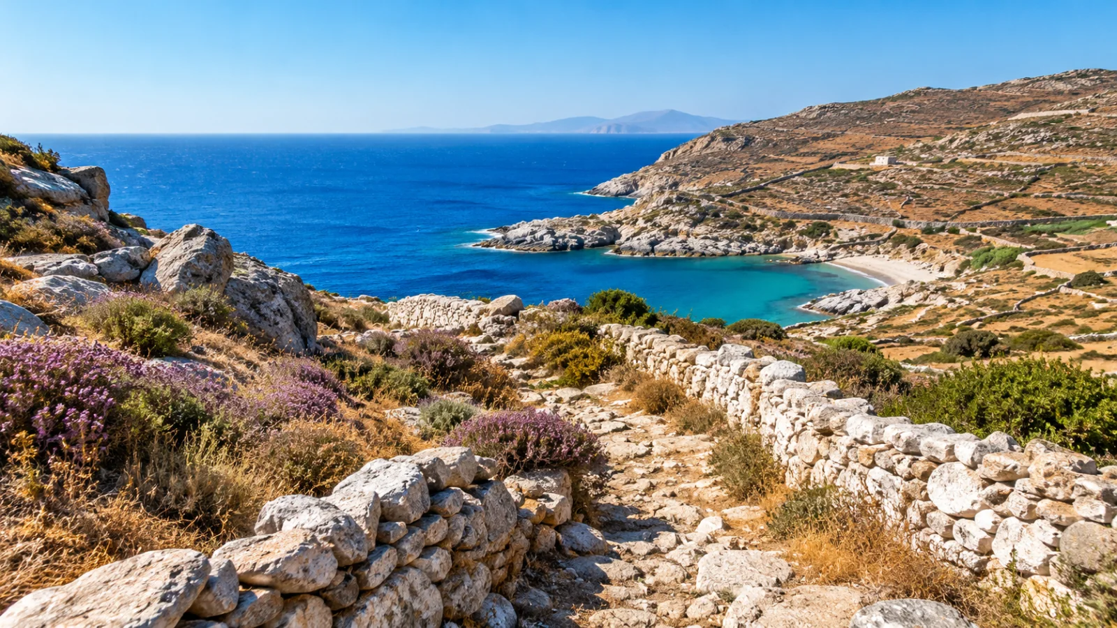 Dry-stone walls and low island hills above a blue cove