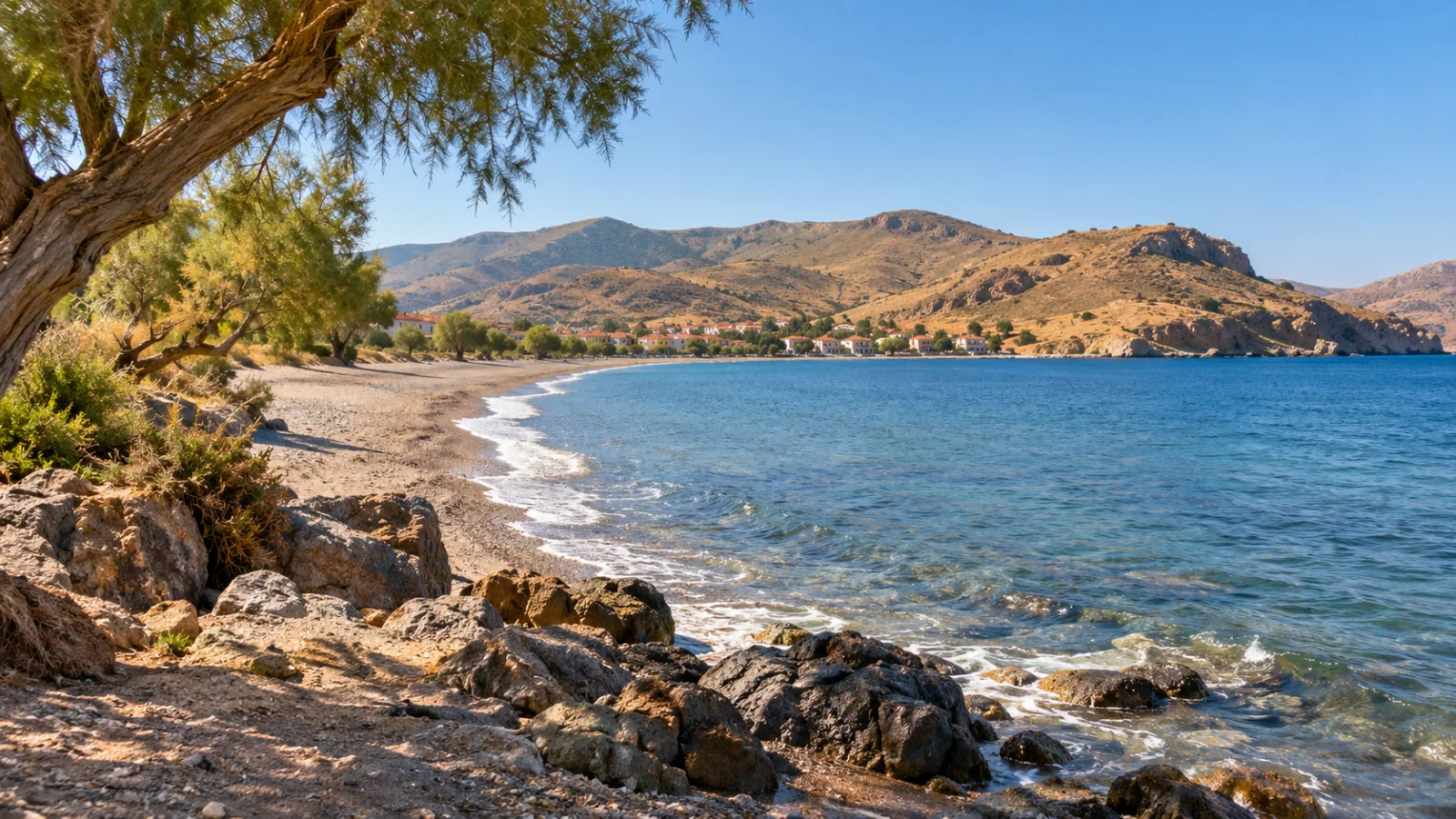 Rocky shore and broad bay beneath dry Aegean hills